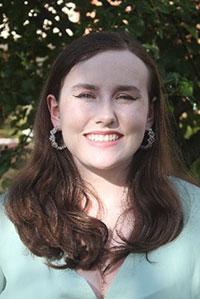 woman with dark brown hair wearing a mint color blouse