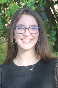 woman with brown hair wearing a balck blouse and glasses