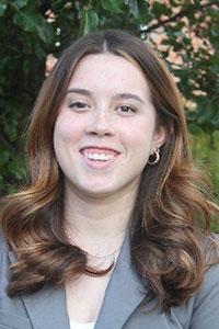 woman with brown hair wearing a grey suit jacket