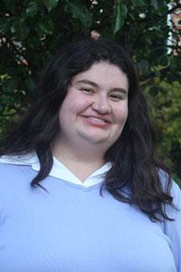 woman with black hair wearing a light blue sweater